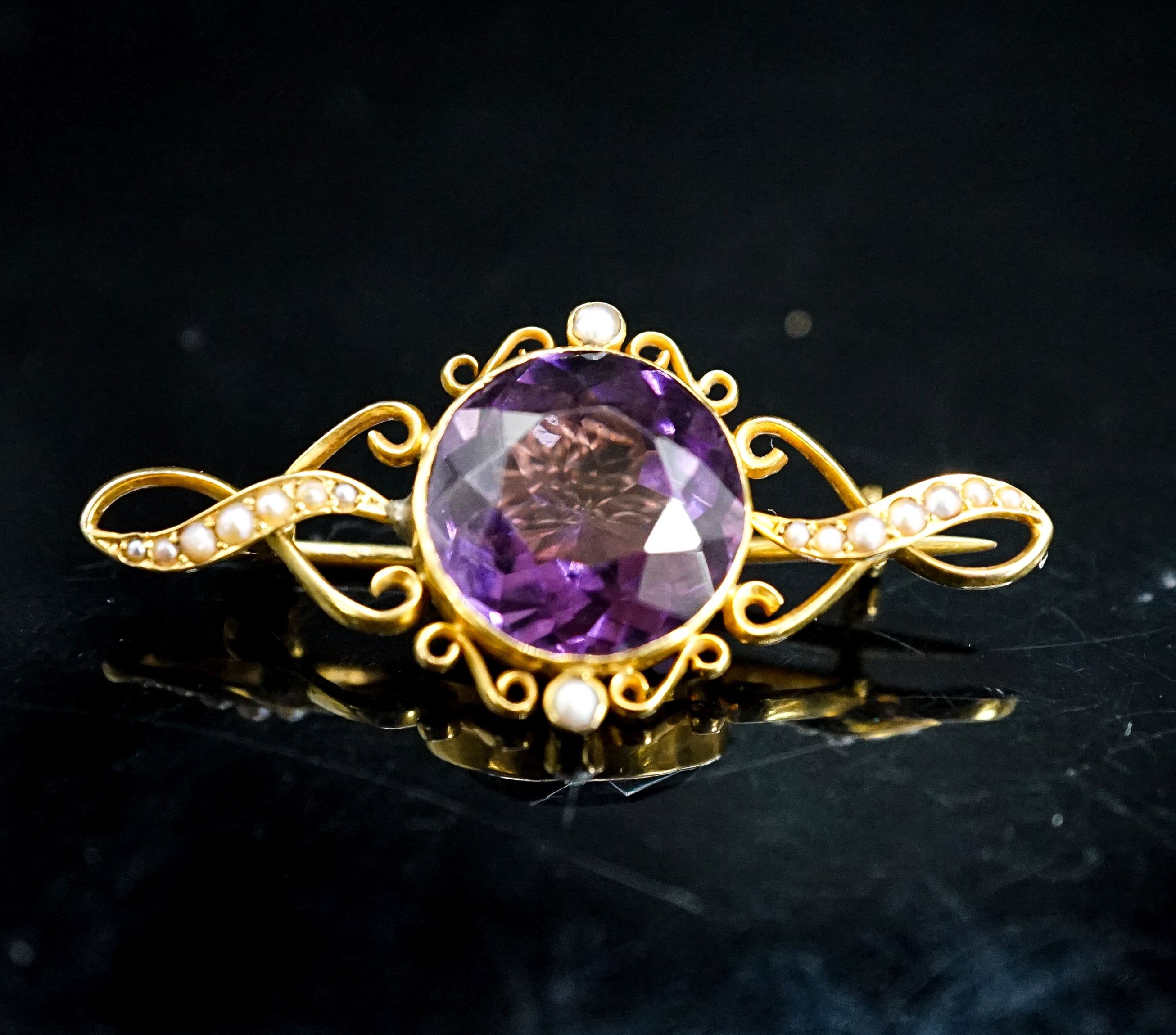 An early 20th century yellow metal, amethyst and seed pearl set brooch, 42mm, gross weight 5.2 grams.